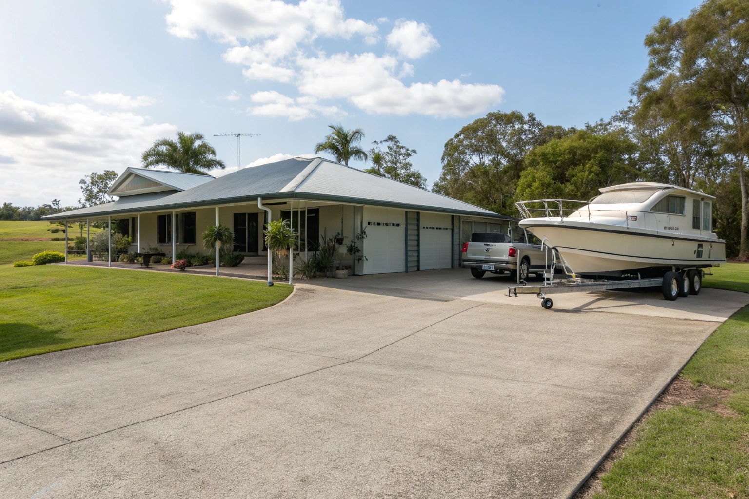 Double concrete driveway Townsville home with boat and caravan